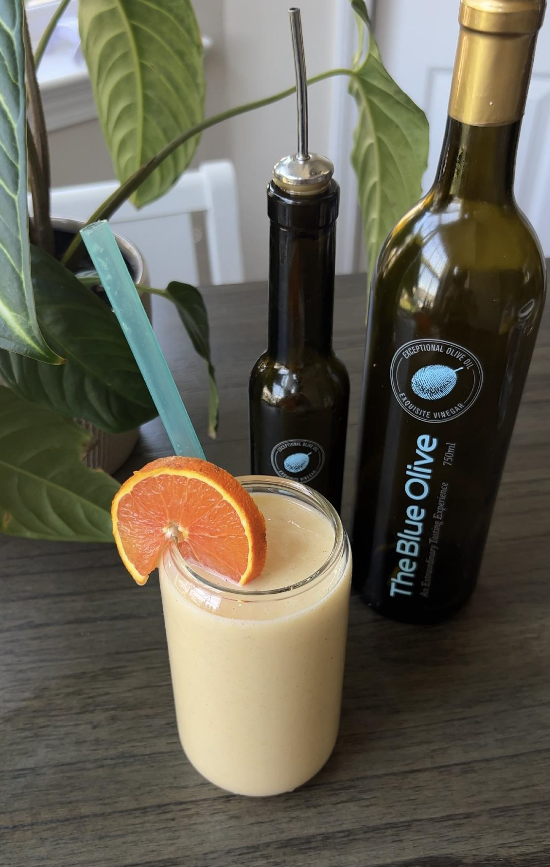 nature's candy smoothie in a glass surrounded by the blue olive vinegar bottles