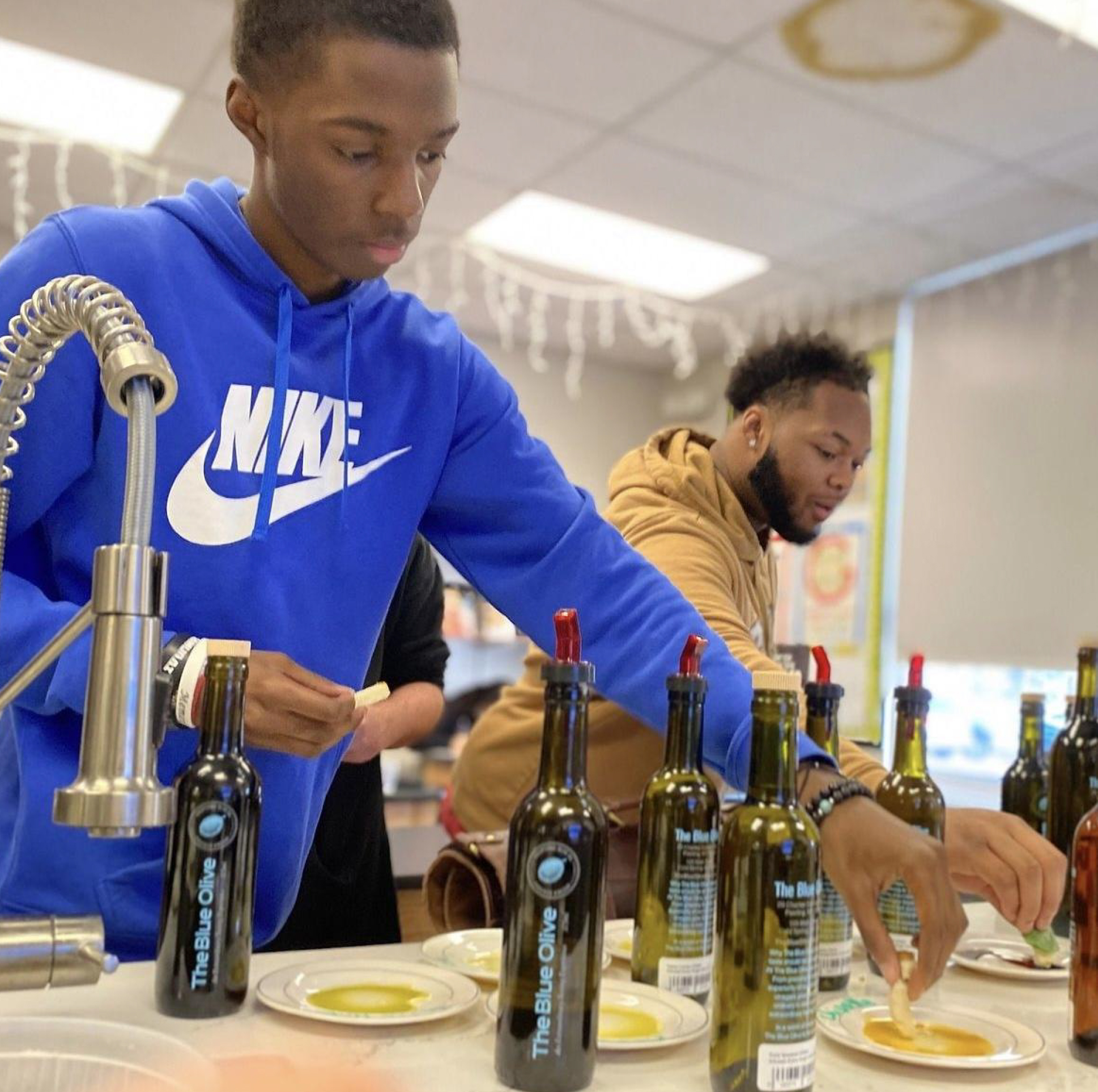 student in blue hoodie using olive oil